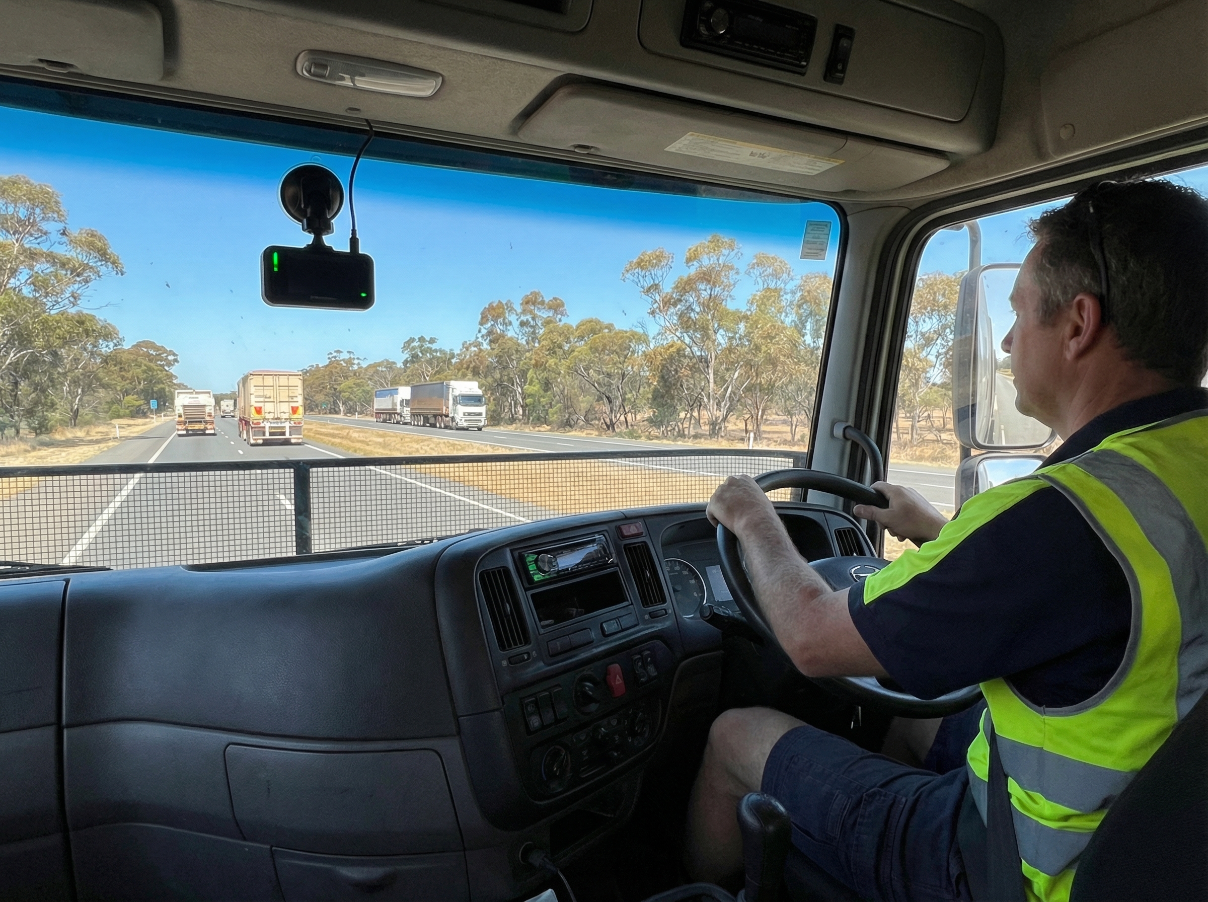 Heavy truck cab interior with AI dash cam mounted on windscreen monitoring driver