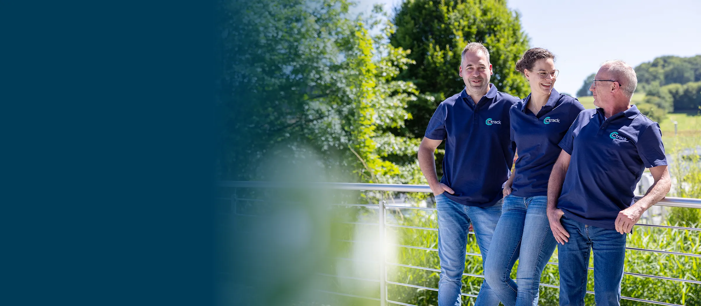 Service-Technikerin und Fuhrparkleiter im Gespräch vor einem Lkw auf einem deutschen Speditionshof während der blauen Stunde, Subjekt rechts, freie Fläche links