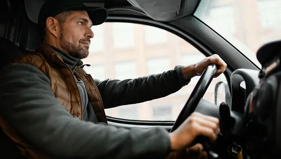 Fahrer in einem links gelenkten Nutzfahrzeug, vorbereitet für ereignisbasierte Video-Telematik