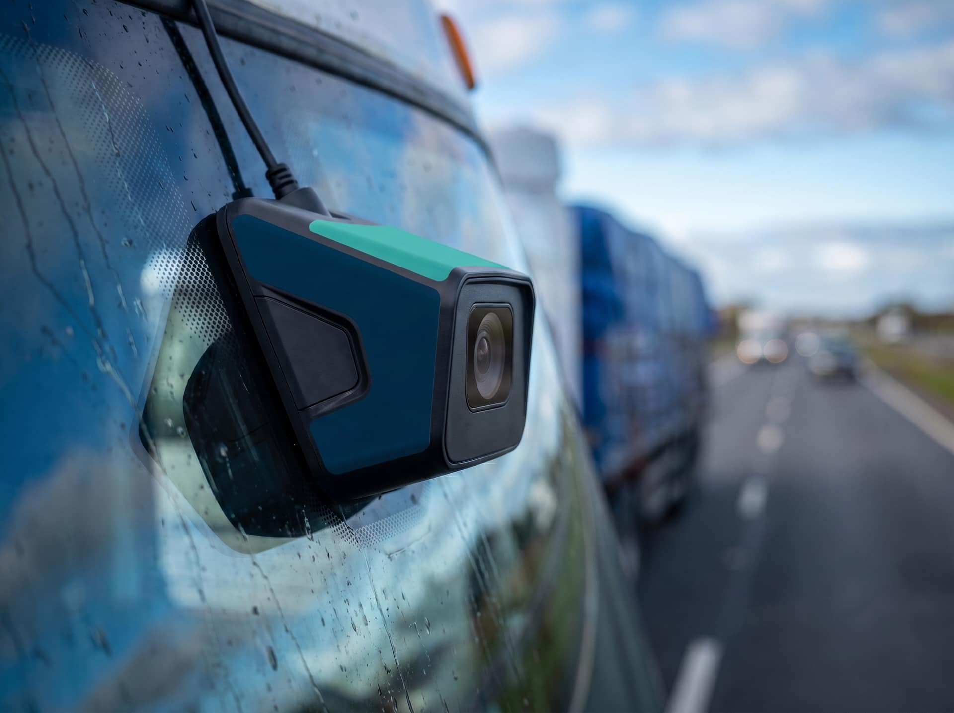 Close crop of an ADAS forward sensor on a truck bumper with the road blurred behind